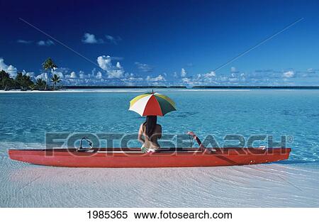 Stock Photography - French Polynesia, Tetiaroa, Local Woman With Umbrella In Outrigger Canoe On Sandbar, View From Behind.. Fotosearch