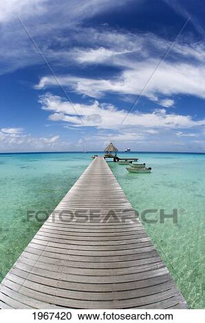Stock Image - French Polynesia, Tuamotu Islands, Rangiroa Atoll, Resort Pier And Boats.. Fotosearch