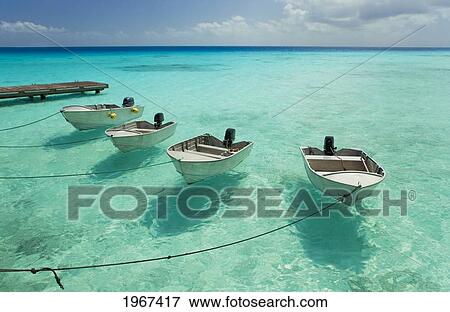Stock Photo - French Polynesia, Tuamotu Islands, Rangiroa Atoll, Boats Tied To Resort Pier.. Fotosearch