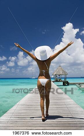 French Polynesia, Tuamotu Islands, Rangiroa Atoll, Woman Walking Down Ocean Pier, View From Behind. View Large Photo Image Stock Photograph - French Polynesia, Tuamotu Islands, Rangiroa Atoll, Woman Walking Down Ocean Pier, View From Behind.. Fotosearch