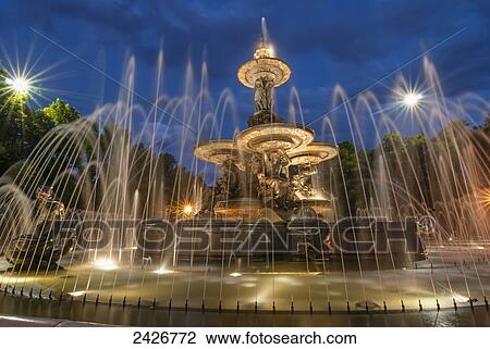 Stock Image - French-style public water fountain in blue light; Mendoza, Argentina. Fotosearch