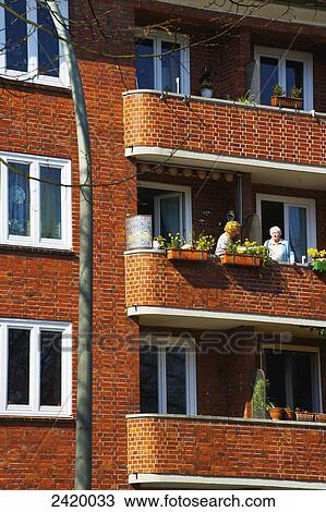 Friends enjoying the balcony in a brick building; Hamburg, Germany View Large Photo Image Stock Image - Friends enjoying the balcony in a brick building; Hamburg, Germany. Fotosearch