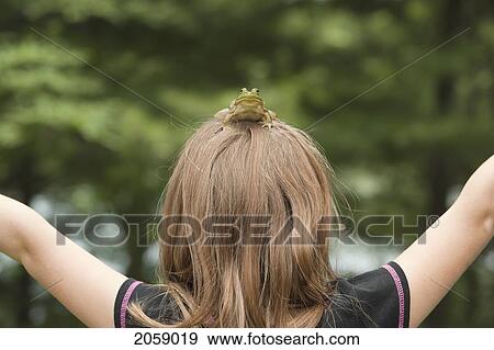 Stock Photo - Frog Sitting On The Top Of Young Girl's Head, Ontario, Canada. Fotosearch