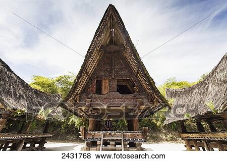 Front gable finely carved and painted with geometric motifs in red, white, and black of a traditional boat-shaped Toba Batak house (jabu) at Huta Bolon Museum in Simanindo village on Samosir Island, Lake Toba, North Sumatra, Indonesia View Large Photo Image Stock Photo - Front gable finely carved and painted with geometric motifs in red, white, and black of a traditional boat-shaped Toba Batak house (jabu) at Huta Bolon Museum in Simanindo village on Samosir Island, Lake Toba, North Sumatra, Indonesia. Fotosearch