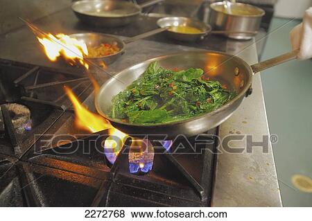 Frying pan full of greens in a restaurant kitchen; boston massachusetts usa View Large Photo Image Stock Photo - Frying pan full of greens in a restaurant kitchen; boston massachusetts usa. Fotosearch