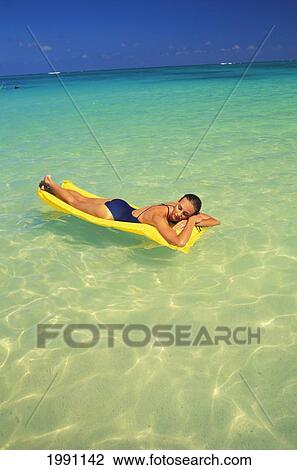 Full Length View Of Woman Laying On Yellow Raft, Floating Shallow Ocean Turquoise, Eyes Closed Sunbathing View Large Photo Image Stock Image - Full Length View Of Woman Laying On Yellow Raft, Floating Shallow Ocean Turquoise, Eyes Closed Sunbathing. Fotosearch