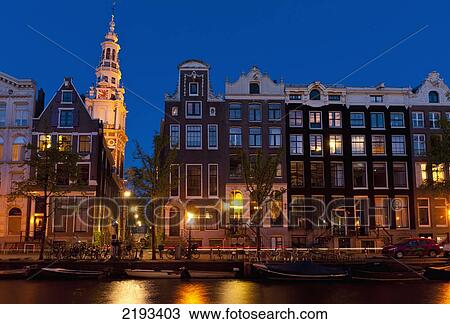 Stock Image - Gabled Houses At Dusk With The Spire Of The Zuiderkerk Church Behindamsterdam, Holland.. Fotosearch