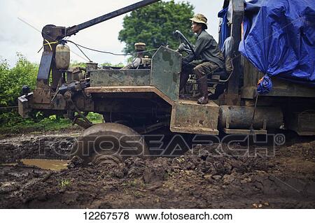 Stock Photo - Gas truck making its way through rainy season mud; Mondulkiri, Cambodia. Fotosearch