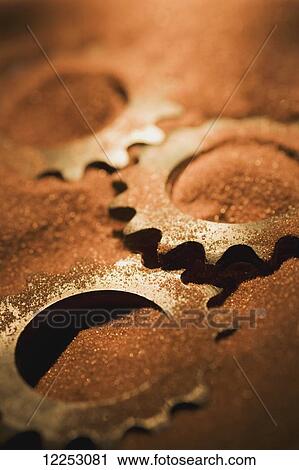Stock Image - Gears covered in sand. Fotosearch