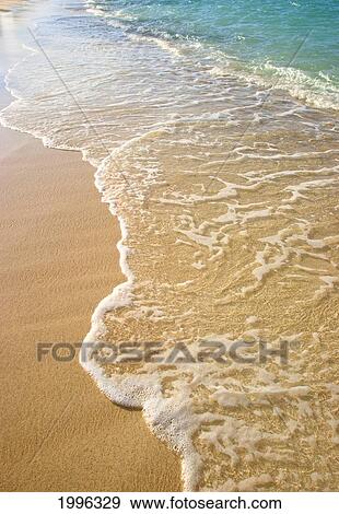 Stock Photo - Gentle Waves Washing Onto Sandy Tropical Beach. Fotosearch