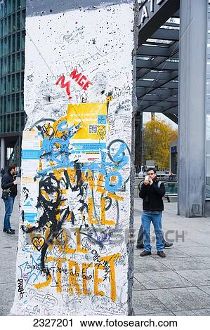Germany, Berlin, Iron Curtain; Potsdamer Platz, Tourists watching pieces of original Berlin Wall View Large Photo Image Stock Image - Germany, Berlin, Iron Curtain; Potsdamer Platz, Tourists watching pieces of original Berlin Wall. Fotosearch