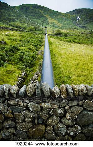 Picture - Giant pipe work traveling down hill from reservoir for Hydro-Electric Power Plant, Snowdonia National Park; Nant Gwynant, North Wales. Fotosearch