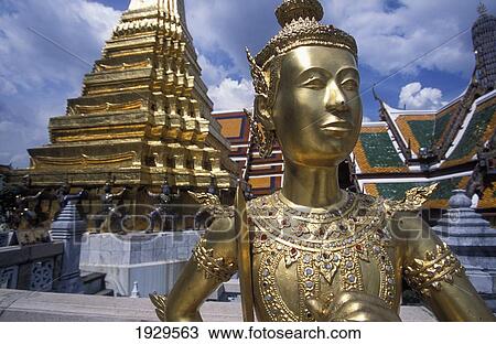 Stock Image - Gilded figure at the Buddhist temple, Wat Phra Keo in Bangkok. Thailand.. Fotosearch