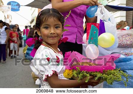 Stock Photo - Girl Carrying A Gift Basket At The Jueves De Comadres Market During Carnaval Chapaco, Tarija, Bolivia. Fotosearch