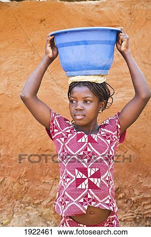 Stock Image - Girl Carrying Bowl On Head. Fotosearch