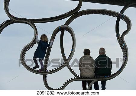 Stock Image - Girl Climbing On 'the Longest Bench', Littlehampton, West Sussex, Uk. Fotosearch