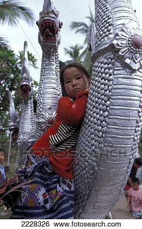Stock Photograph - Girl Clinging Onto Dragon Heads At Wat Phra Maha That, Luang Phrabang / Prabang, Laos.. Fotosearch