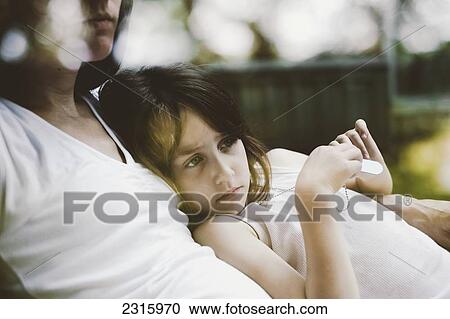 Girl Cuddling Against Her Mother On A Chair In The Backyard; Otterburn Park Quebec Canada View Large Photo Image Stock Image - Girl Cuddling Against Her Mother On A Chair In The Backyard; Otterburn Park Quebec Canada. Fotosearch