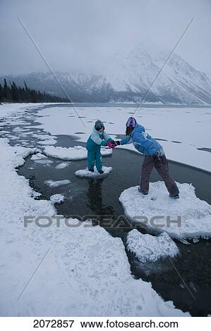 Girl Helping Sister Across Ice Floes On Freezing Lake, Kathleen Lake, Kluane National Park, Yukon Territory, Canada View Large Photo Image Stock Photo - Girl Helping Sister Across Ice Floes On Freezing Lake, Kathleen Lake, Kluane National Park, Yukon Territory, Canada. Fotosearch