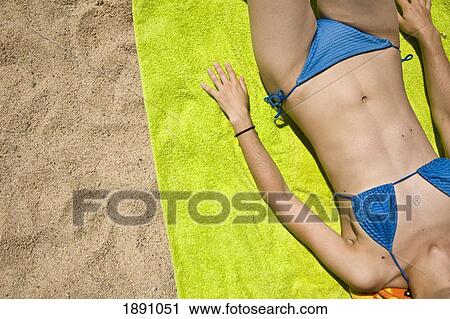 Stock Image - Girl In Blue Bikini Relaxing On Sandy Beach. Fotosearch