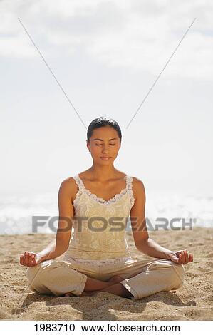 Stock Image - Girl On Beach Meditating.. Fotosearch