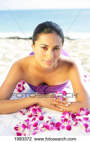 Stock Image - Girl On Beach With Orchids.. Fotosearch