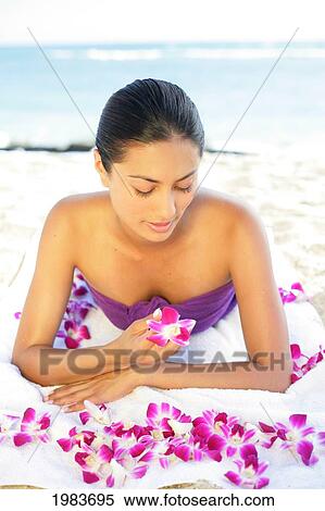 Stock Photography - Girl On Beach With Orchids.. Fotosearch