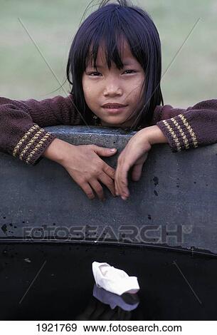 Stock Photo - Girl Playing With Paper Boat In Bronze Urn; Forbidden City, Hue City, Vietnam. Fotosearch
