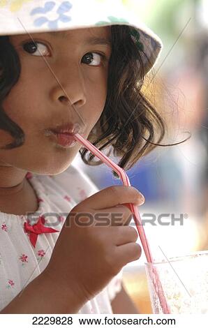 Stock Photo - Girl Sipping Milkshake In Sunshine, Formentera, Spain (C) Sue Carpenter/Axiom. Fotosearch