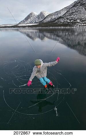 Stock Photo - Girl Skating On Frozen Lake In Winter, Kusawa Lake Territorial Park, Yukon, Canada. Fotosearch