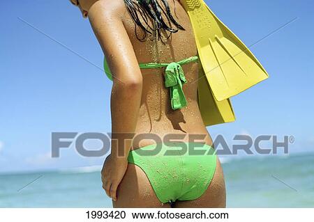 Girl Standing On Tropical Beach Wearing Green Bikini, Holding Fins, Wet And Sandy, View From Behind View Large Photo Image Stock Image - Girl Standing On Tropical Beach Wearing Green Bikini, Holding Fins, Wet And Sandy, View From Behind. Fotosearch
