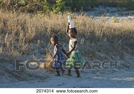 Girls Carrying Water On Their Heads In Mangily, Toliara Province, Madagascar View Large Photo Image Picture - Girls Carrying Water On Their Heads In Mangily, Toliara Province, Madagascar. Fotosearch
