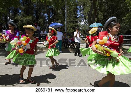 Stock Image - Girls Dancing With Festive Baskets In The Entrada De Comadritas Parade During The Carnaval Chapaco, Tarija, Bolivia. Fotosearch
