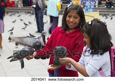 Stock Image - Girls Feeding Pigeons On Plaza Murillo, La Paz, Bolivia. Fotosearch