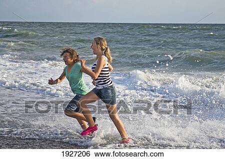 Girls Running In Waves On Beach, West Jutland, Denmark View Large Photo Image Stock Photograph - Girls Running In Waves On Beach, West Jutland, Denmark. Fotosearch
