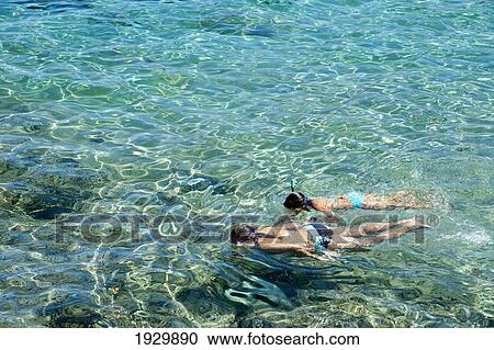 Stock Image - Girls Snorkeling In The Clear Waters Of Cala Sant Pere, Alcudia, Mallorca, Balearic Islands, Spain. Fotosearch