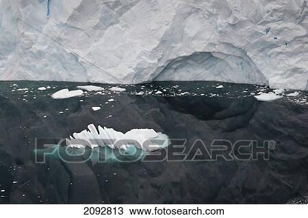 Stock Image - Glacier Reflected In The Water Along The Coastline; Antarctica. Fotosearch