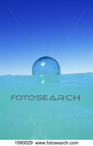 Glass Fishing Float Suspended In Turquoise Ocean With Blue Sky Background. View Large Photo Image Stock Photo - Glass Fishing Float Suspended In Turquoise Ocean With Blue Sky Background.. Fotosearch