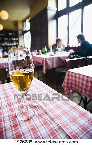 Stock Photography - Glass Of Beer On Table In Restaurant; Berlin, Germany. Fotosearch