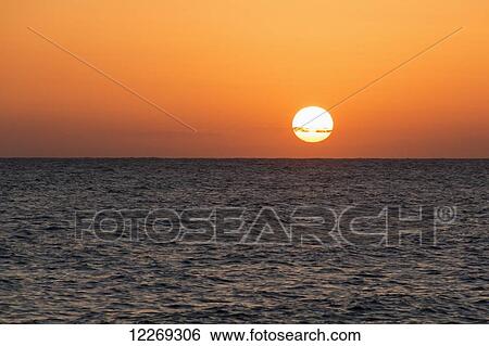 Glowing sun over the ocean and horizon at sunset; Paphos, Cyprus View Large Photo Image Stock Photograph - Glowing sun over the ocean and horizon at sunset; Paphos, Cyprus. Fotosearch