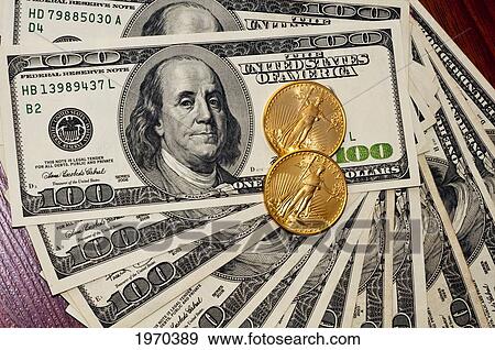 Gold Coins On A Pile Of Hundred Dollar Bills View Large Photo Image Stock Photo - Gold Coins On A Pile Of Hundred Dollar Bills. Fotosearch