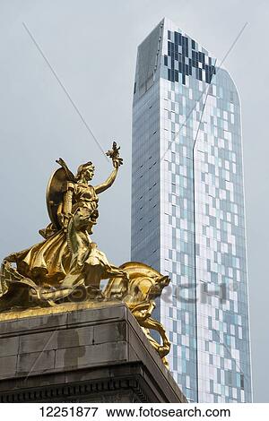 Gold statue and residential skyscraper against a blue sky; New York City, New York, United States of America View Large Photo Image Stock Photo - Gold statue and residential skyscraper against a blue sky; New York City, New York, United States of America. Fotosearch