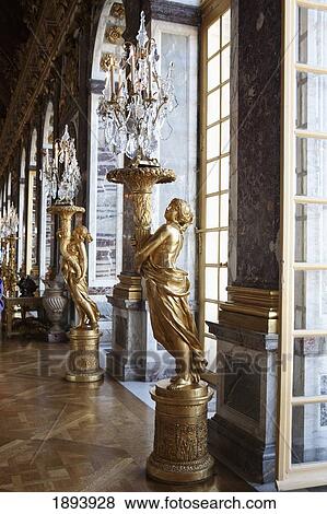 Gold Statues Along The Windows Holding Large Glass Candle Chandeliers; Paris, France View Large Photo Image Stock Photo - Gold Statues Along The Windows Holding Large Glass Candle Chandeliers; Paris, France. Fotosearch