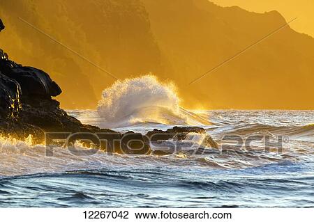 Stock Image - Golden waves looking down the Na Pali Coast; Wainiha, Kauai, Hawaii, United States of America. Fotosearch