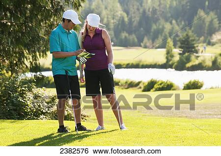Stock Photograph - Golfers checking their scores at the Whistler Golf Course; Whistler, British Columbia, Canada. Fotosearch