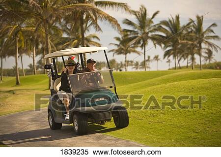 Stock Photography - Golfers In Golf Cart In Estella Del Mar Golf Country Club, Robert Trent Jone Jr. Championship Course Design; Mazatlan, Sinaloa, Mexico. Fotosearch