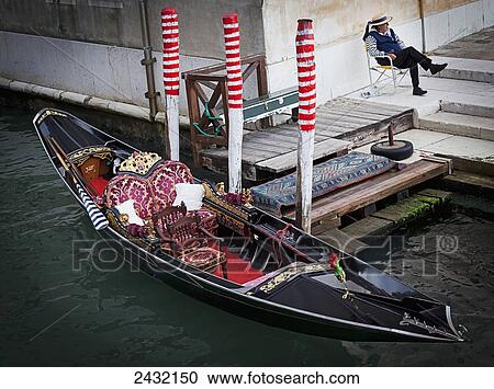 Stock Image - Gondola and gondolier; Venice, Italy. Fotosearch
