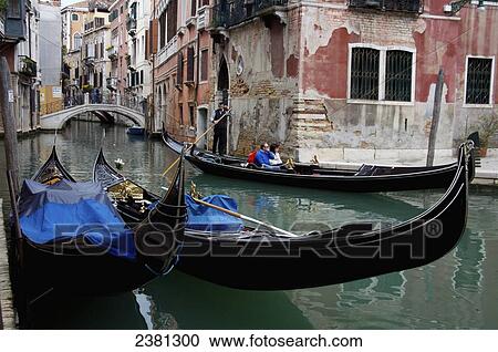 Stock Image - Gondolas in a canal; Venice, Italy. Fotosearch