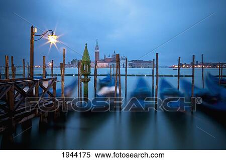 Gondolas Moored By A Wooden Pier With A Light At Dusk; Venice Venezia Italy View Large Photo Image Stock Photography - Gondolas Moored By A Wooden Pier With A Light At Dusk; Venice Venezia Italy. Fotosearch