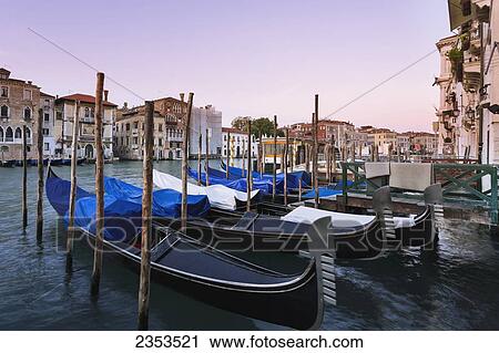 Stock Image - Gondolas Mooring In A Row; Venice, Italy. Fotosearch